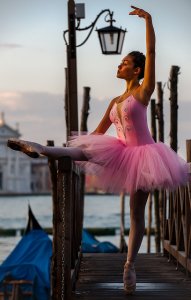 Une danseuse en tutu et justaucorps roses à l'extérieur.