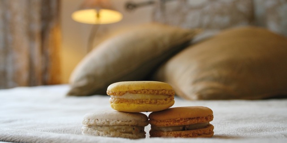Trois macarons posés sur un lit.
