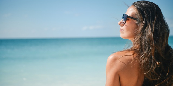 Femme en maillot de bain devant la mer.