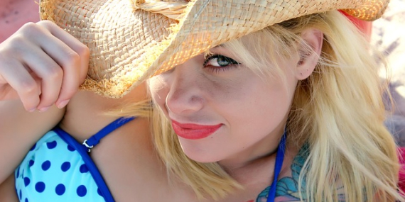 Jeune femme blonde à chapeau et en maillot de bain.