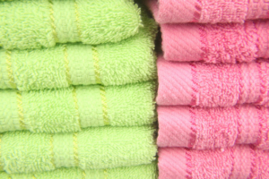 Serviettes de bain pliées, vertes et roses.