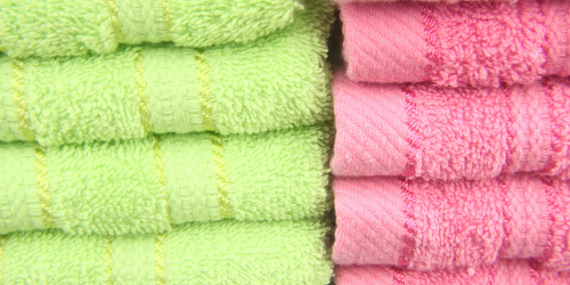 Serviettes de bain pliées, vertes et roses.