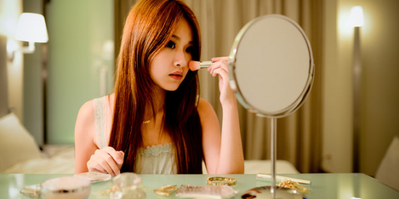 Une jeune femme se maquille.