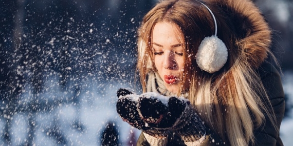 Jeune femme qui souffle dans la neige.