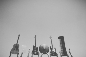 Des instruments de musiques rock tenus en l'air à bout de bras.